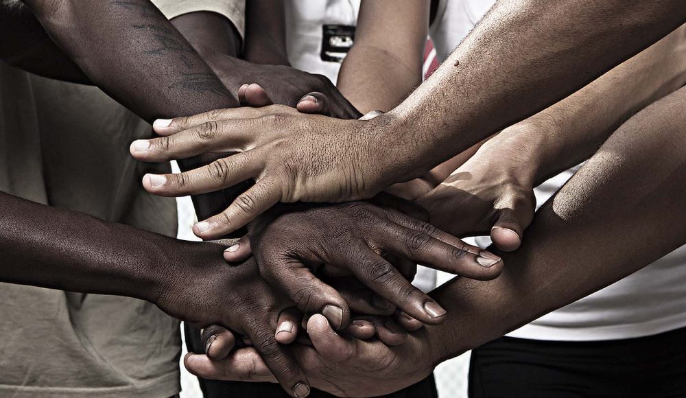 Closeup portrait of group with mixed race people with hands together